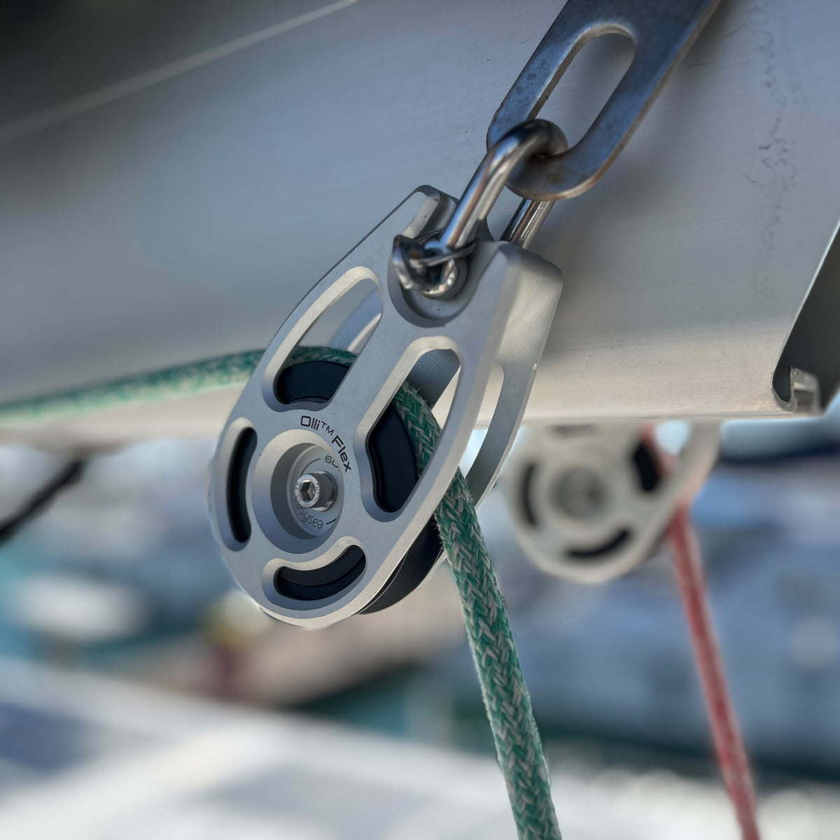 Olli Flex modular blocks in use under the boom of a sailboat, sheets running through